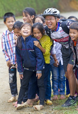 A cyclist makes friends with a group of school children near Cuc Phuong National Park.