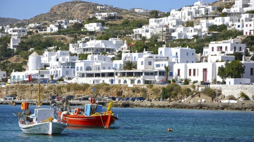Mykonos' harbour is surrounded by gleaming white houses, resorts and developments.