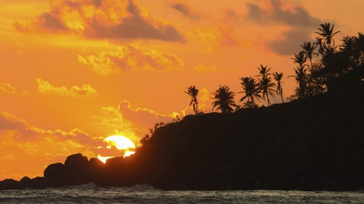 Sunset on the western point of the south coast surf beach at Mirissa, Sri Lanka.