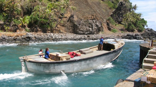 Pitcairn Islanders launch a longboat from Bounty Bay to meet a supply ship anchored offshore.