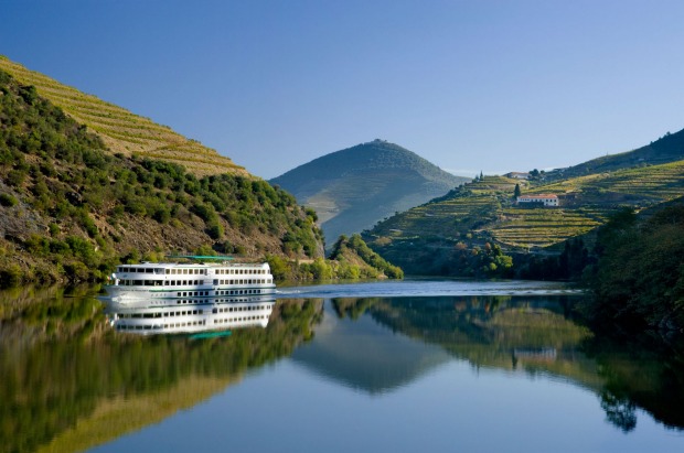 A boat cruises the Douro river between Regua and Pinhao, the Alto Douro district, Portugal.