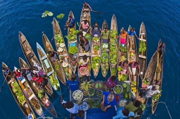 A boat market visits a cruise ship in the Solomon Islands.