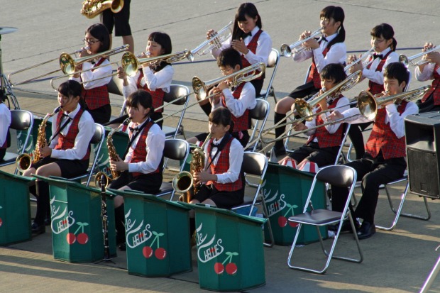A high-school band gives the ship a send-off from Kagoshima port.