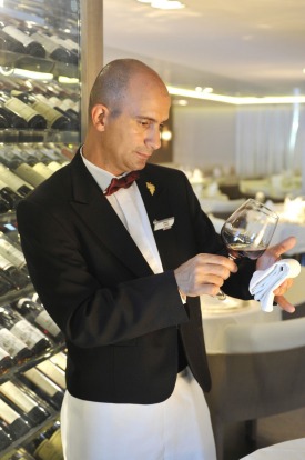 The sommelier prepares wine in the main Deck 2 dining room. Service style is defiantly French.