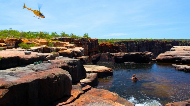 The Great Escape's helicopter dives over the King George Falls as rockpool swimmers look on.