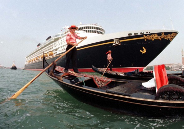 The massive bow of 'Disney Magic' dwarfs the traditional Gondaliers as it departs Venice, Italy.
