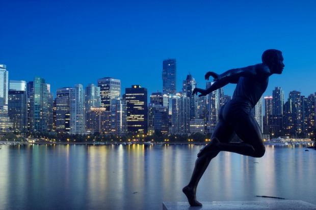 Statue of harry jerome with city in background in Stanley Park, Vancouver.