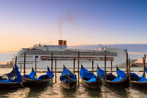 A cruise ship arrives in Venice at sunrise.