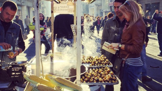 Couple buying grilled corn on the cob on famous Istiklal Avenue, Istanbul.