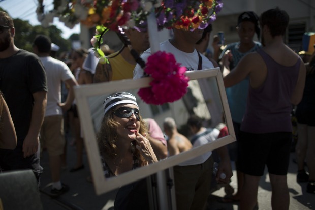 A reveller checks her makeup as she attends the "Carmelitas" block party during Carnival celebrations in Rio de Janeiro, ...