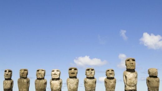 Moai statues line a stone platform at the heritage listed site of Ahu Tongariki, Easter Island.