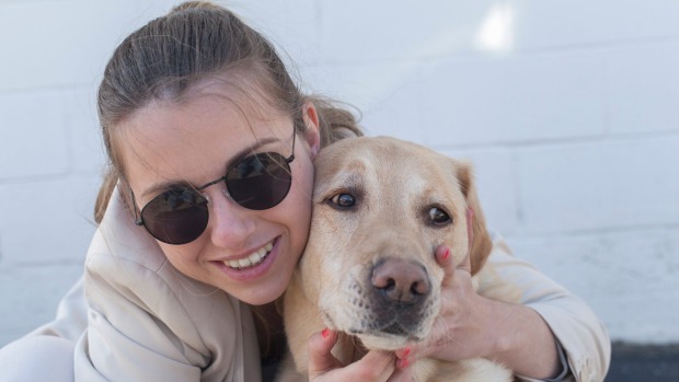 Young blind woman hugging her service dog