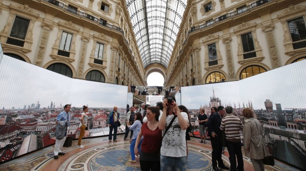 A tourist takes photos of an installation on Milan's history at the restored Galleria Vittorio Emanuele II in Milan, ...