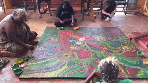 Women at Tjala Arts, in Amata community, painting the Honey Ant Dreaming.