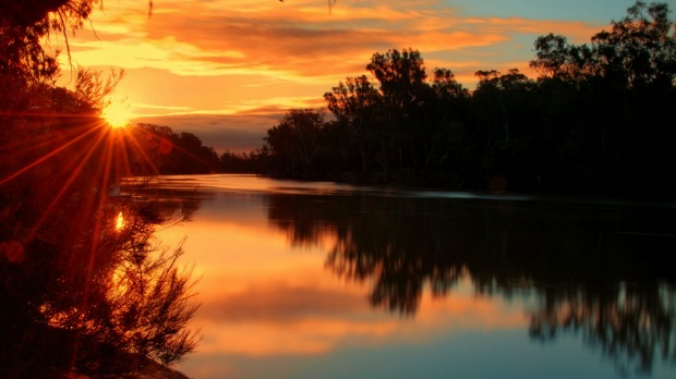 The rising sun casts a glow across the Murray River.