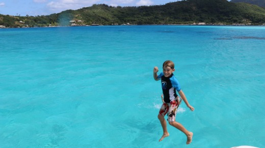 Bound for glory: Taj leaps off the boat into the crystal-clear waters of Tahiti