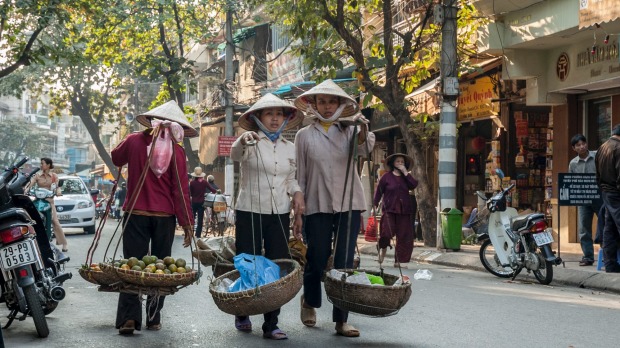 Local women stroll through the centre of Hanoi's Old Quarter.