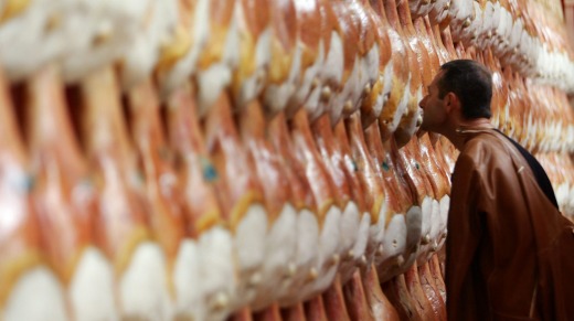 A visitor looks over prosciutto at the Salone del Gusto.