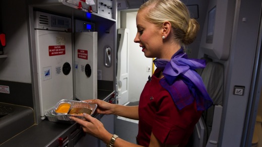 A Virgin Australia flight attendant prepares trout to serve to business class passengers.