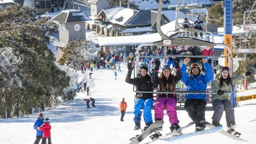 A bevy of keen learner boarders head to the top of Bourke Street on Mt Buller for their lesson.