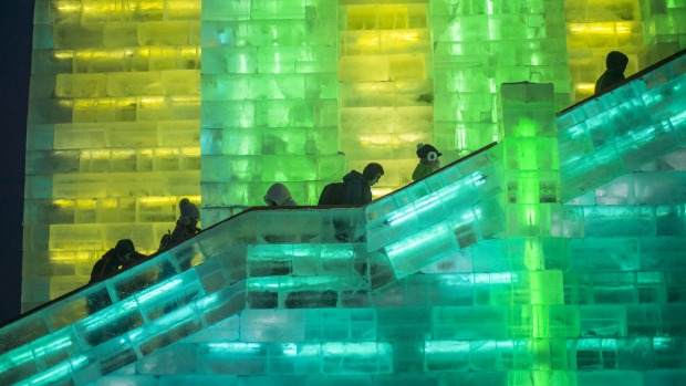 Visitors walks the stairs of an ice tower at the China Ice and Snow World on the eve of the opening ceremony of the ...