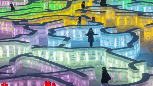 Visitors walk on an ice maze at the China Ice and Snow World during the Harbin International Ice and Snow Festival in ...