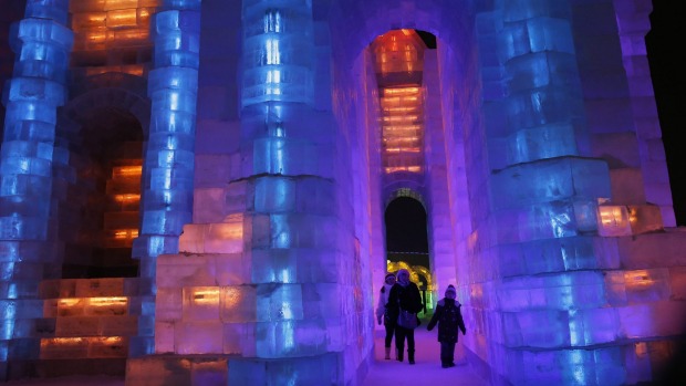 Ice sculptures illuminated by blue and purple coloured lights at the Harbin International Ice and Snow Festival in the ...