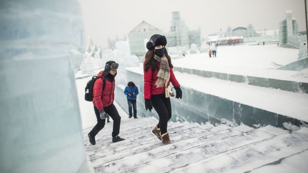 Visitors walk on an ice castle at the China Ice and Snow World during the Harbin International Ice and Snow Festival in ...