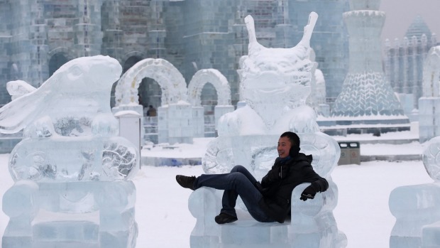 Visitors walk past a train-shaped ice sculpture.
