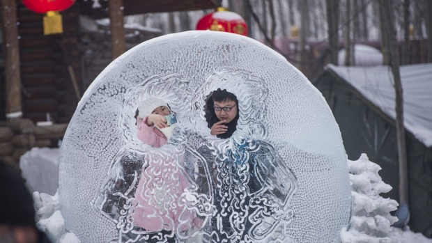 A couple poses at the China Ice and Snow World on the eve of the opening ceremony of the Harbin International Ice and ...