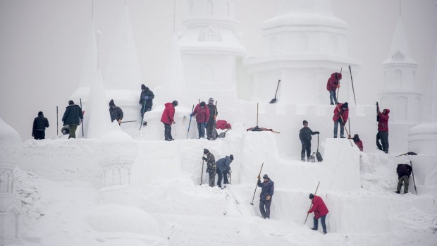 Ice sculptors carve a snow sculpture at the China Ice and Snow World on the eve of the opening ceremony of the Harbin ...