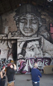 Tourists on the Alternative Berlin tour look at art inside an abandoned building.