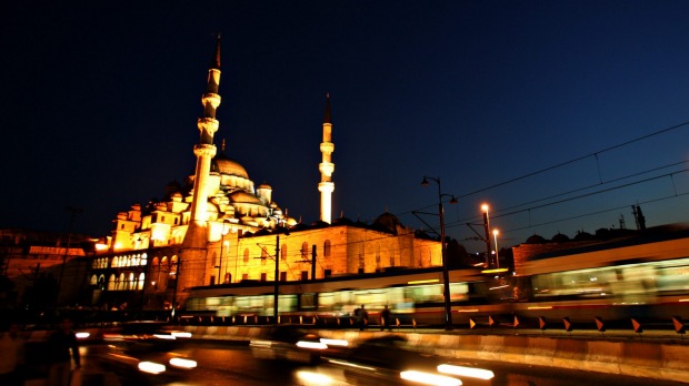 A train passes the 17th century Ottoman era mosque Yeni Cami (New Mosque) in downtown Istanbul.