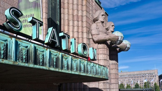 Parodied: Helsinki Central railway station exterior, in Finland, with neo-classical stone figures holding lamps.
