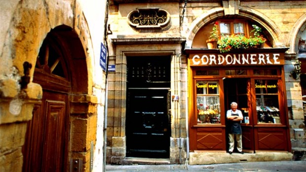 Vive la difference ... a shoemaker stands at his shop door in Lyon.