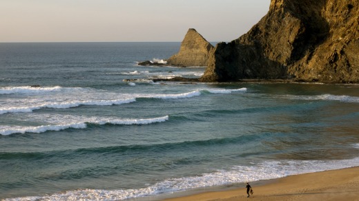 Surfing at Odeceixe beach in the Algarve, Portugal.