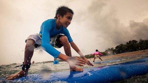 A young boy catches a wave.