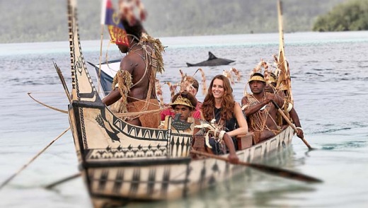 Duchess of Cambridge and Prince William are followed by locals dressed as 'sharks' as they travel in a traditional canoe ...