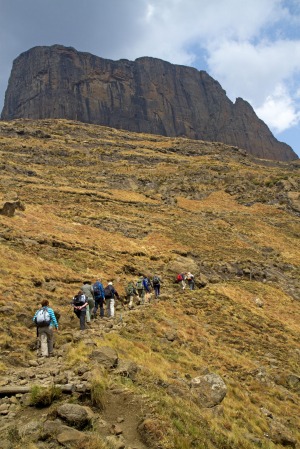 Hikers below Sentinel Peak in South Africa's Drakensberg Mountains.