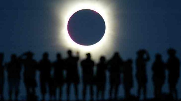 Tourists watch the sun being blocked by the moon during a solar eclipse in the Australian outback town of Lyndhurst, ...