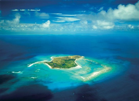 Richard Branson's Necker Island is surrounded by turquoise water and coral reefs.