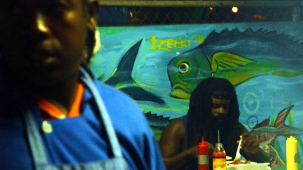 Full of flavour ... a diner enjoys jerk chicken at a restaurant in Montego Bay.