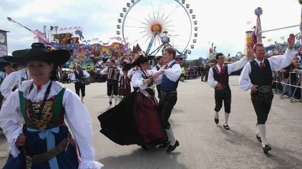 Men dressed in Lederhosen dance with women dressed in Dirndl at  the Parade of Costumes and Riflemen (Trachten- und ...