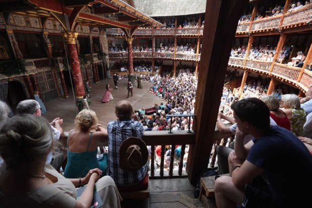 Audience members watch a production of 'A Midsummer Night's Dream' in Shakespeare's Globe Theatre on the south bank of ...
