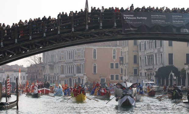 Boats sail under the Accademia Bridge during the water parade, part of the Venice Carnival, in Venice, Italy. The Venice ...