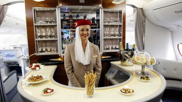 A flight attendant poses behind the bar in the rear of the business class section of Emirates' Airbus A380.