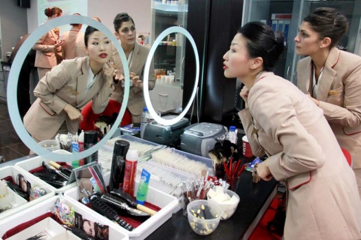 YuJung Kwon, a training instructor for Emirates Airline, left, teaches student Solenne Roussei, right, how to apply her ...
