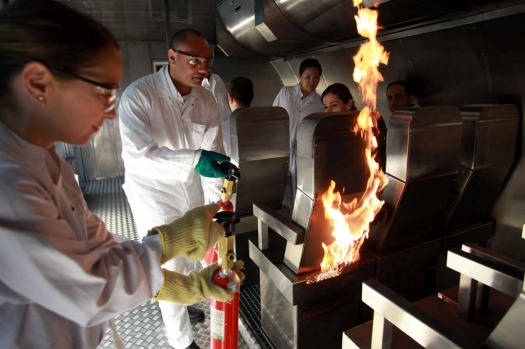 Emirates trainee crew extinguish a fire  after a simulated emergency during a training session at the Emirates Aviation ...