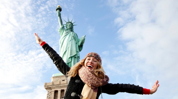 A beautiful young blonde woman  at The Statue of Liberty in New York.