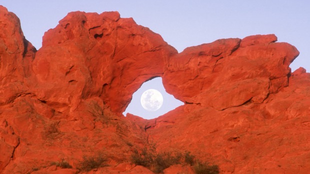 Kissing Camels formation with full moon in arch in Garden of the Gods Park in Colorado Springs Colorado, USA.